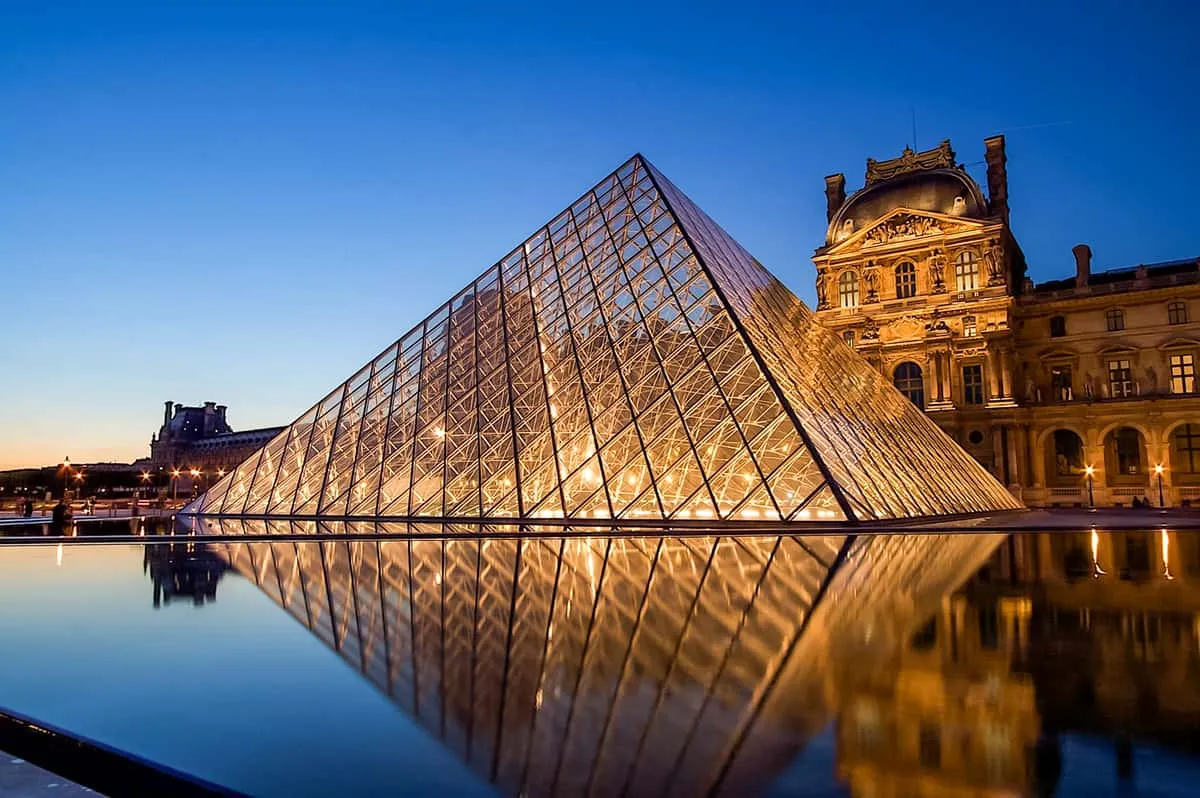 Louvre pyramid and a Seine cruise boat, a combined first-day tour of the museums in Paris