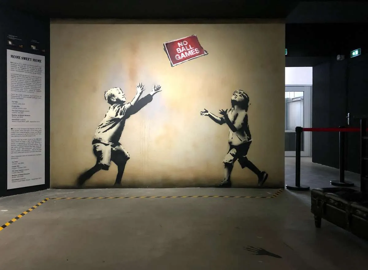 Reproduced Banksy stencils lining the walls of an immersive museum experience in Paris